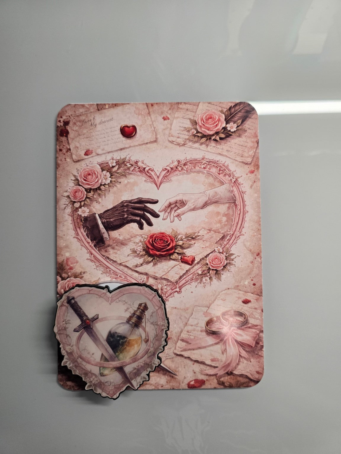 Matching romance inspired MagSafe grip featuring crossed dagger and potion heart design